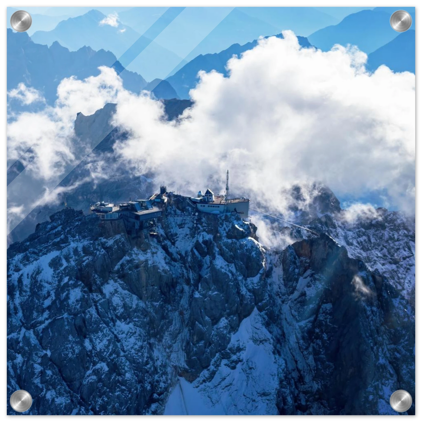 Wandbild alpine majesty gipfelstation im wolkenmeer mit blauen bergsilhouetten