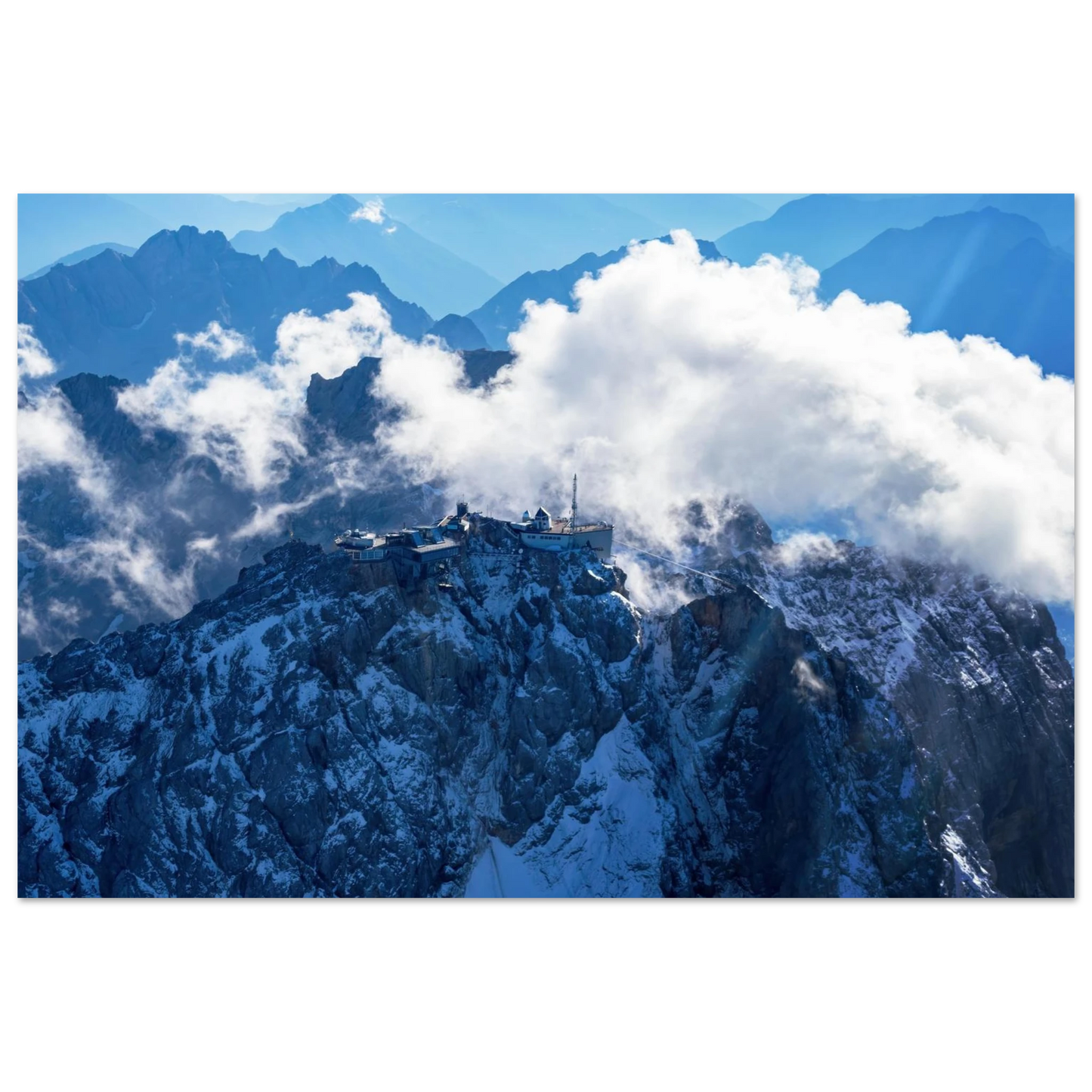 Wandbild alpine majesty gipfelstation im wolkenmeer mit blauen bergsilhouetten