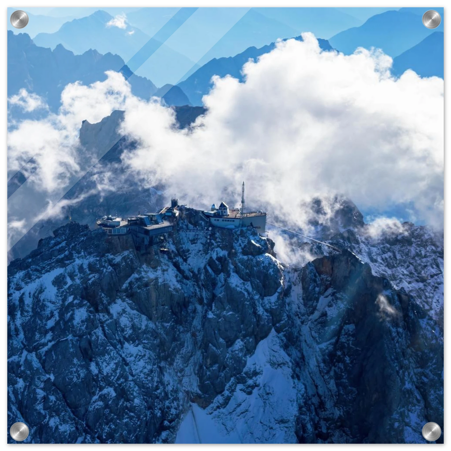 Wandbild alpine majesty gipfelstation im wolkenmeer mit blauen bergsilhouetten