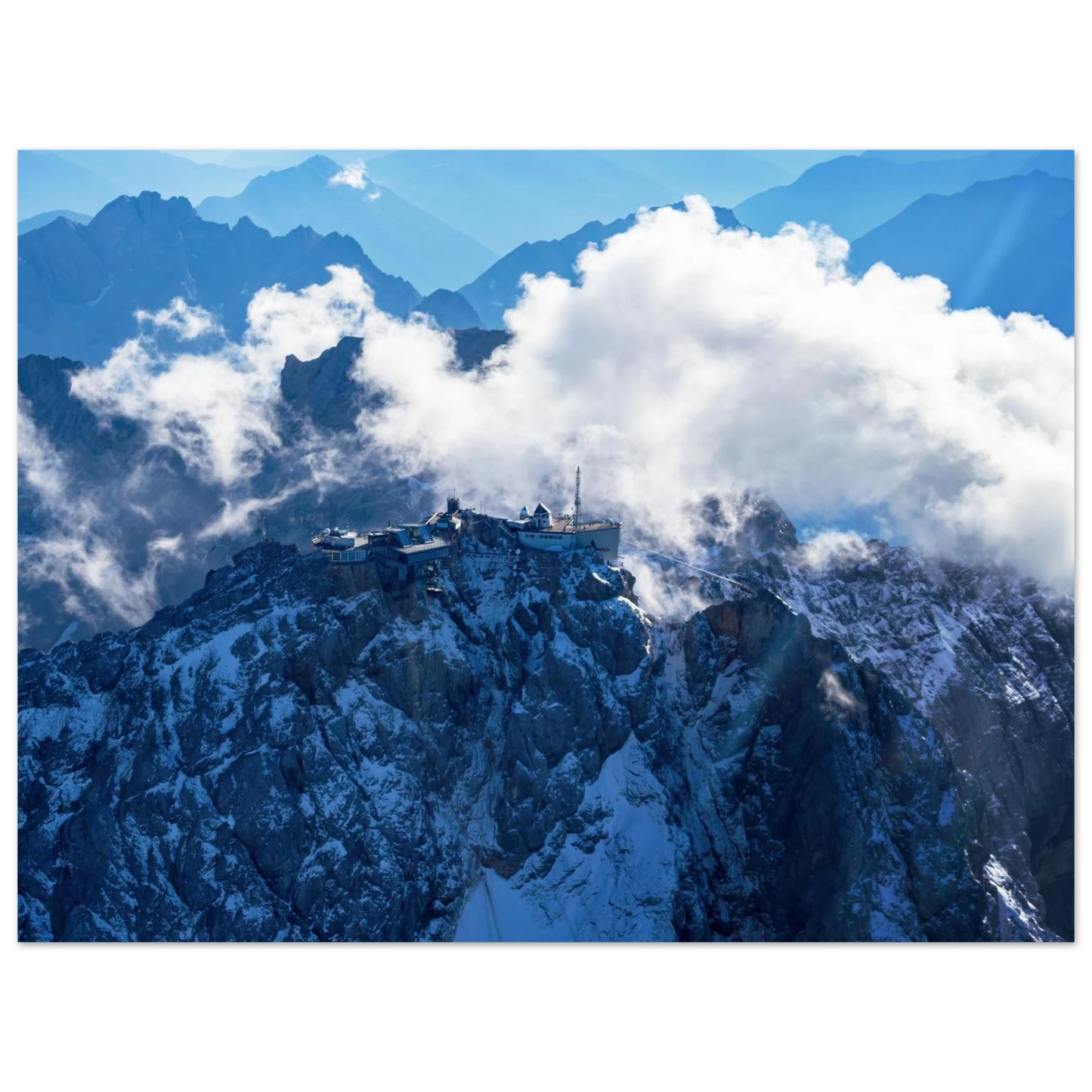 Wandbild alpine majesty gipfelstation im wolkenmeer mit blauen bergsilhouetten