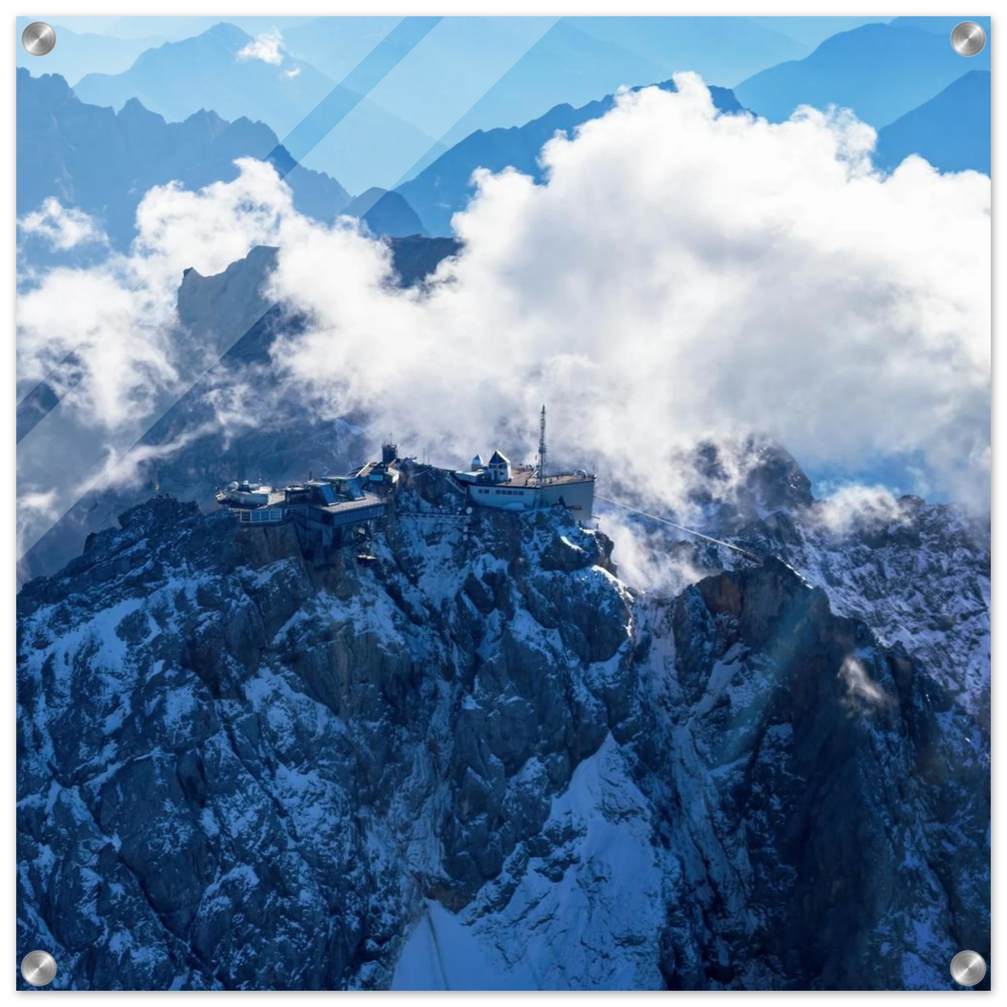 Wandbild alpine majesty gipfelstation im wolkenmeer mit blauen bergsilhouetten